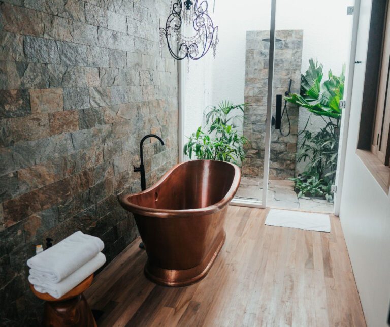 copper bathtub with bamboo plants and floors