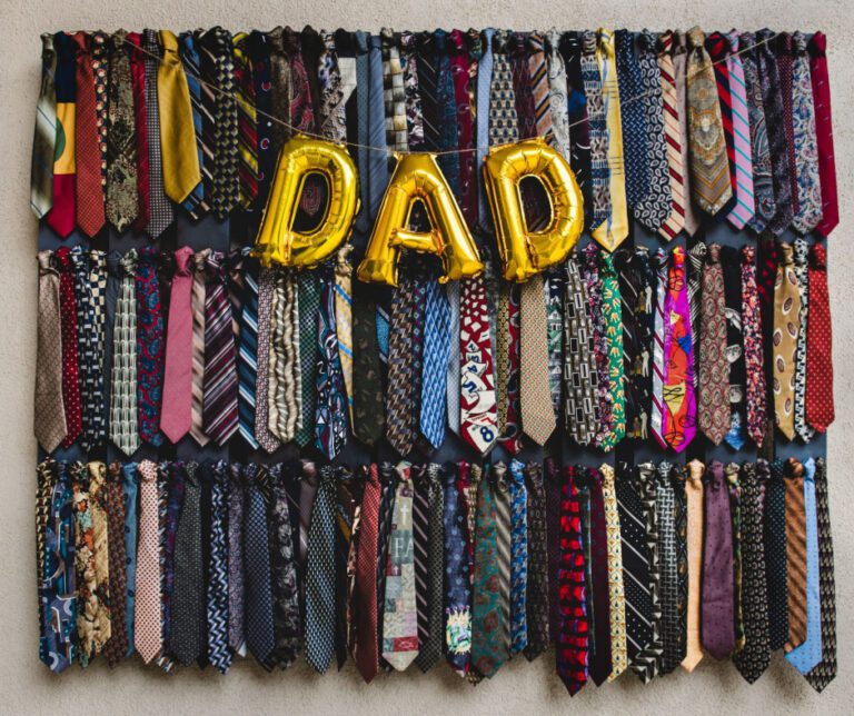 gold Dad balloon with a wall of colorful neckties